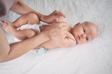 Annem bebek bezi değiştiriyor. Sevimli, duygusal, komik, yeni doğmuş bebek bebek beşikte yatıyor. Bebek eşyaları paketleme şablonu. Sağlıklı çocuk, hastane kavramı ve mutlu annelik. Bebek, bebek. Çocuk odası..