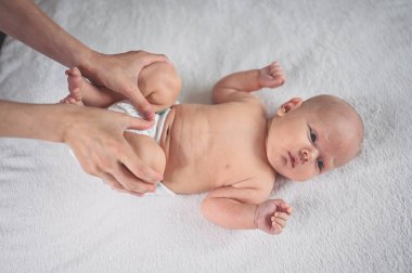 Annem bebek bezi değiştiriyor. Sevimli, duygusal, komik, yeni doğmuş bebek bebek beşikte yatıyor. Bebek eşyaları paketleme şablonu. Sağlıklı çocuk, hastane kavramı ve mutlu annelik. Bebek, bebek. Çocuk odası..