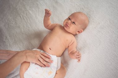 Annem bebek bezi değiştiriyor. Sevimli, duygusal, komik, yeni doğmuş bebek bebek beşikte yatıyor. Bebek eşyaları paketleme şablonu. Sağlıklı çocuk, hastane kavramı ve mutlu annelik. Bebek, bebek. Çocuk odası..