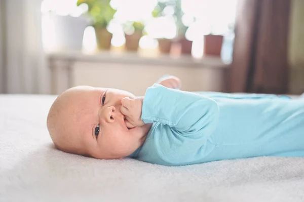 Roztomilý Emocionální Novorozenec Modré Kombinéze Ležící Posteli Výrazy Dětských Tváří — Stock fotografie