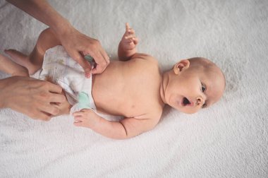 Annem bebek bezi değiştiriyor. Sevimli, duygusal, komik, yeni doğmuş bebek bebek beşikte yatıyor. Bebek eşyaları paketleme şablonu. Sağlıklı çocuk, hastane kavramı ve mutlu annelik. Bebek, bebek. Çocuk odası..