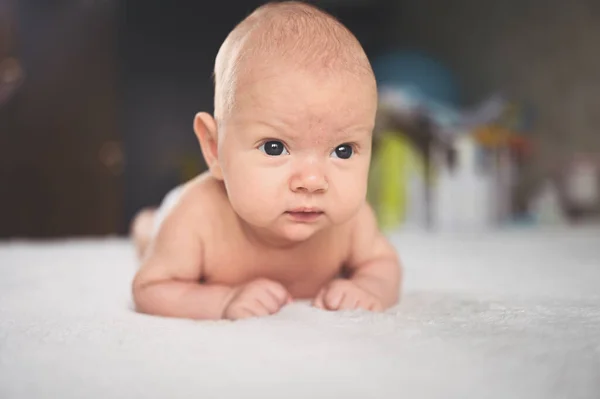 Lindo niño recién nacido divertido emocional acostado en la cama. Bebé expresiones faciales. —  Fotos de Stock