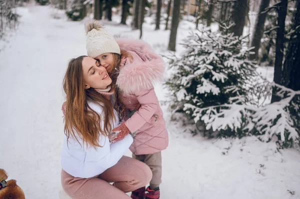 분홍빛 가운데 엄마와 귀여운 소녀가 바깥에 눈덮인 흰색추운 겨울의 속에서 — 스톡 사진