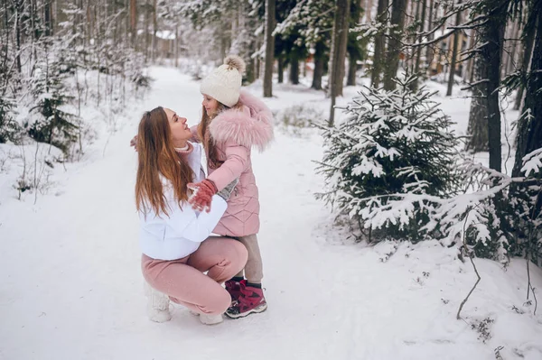 분홍빛 가운데 엄마와 귀여운 소녀가 바깥에 눈덮인 흰색추운 겨울의 속에서 — 스톡 사진