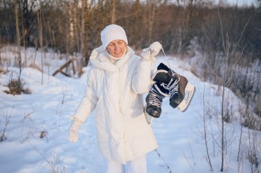 Beyaz, sıcak, güneşli kış aylarında buz patenleriyle oynayan yaşlı, mutlu, olgun bir kadın. Emekli sağlıklı insanlar tatil, kış aktiviteleri, aktif yaşam tarzı konsepti