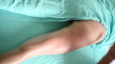 Masaj masasında uzanmış, terapi amaçlı kalça masajından zevk alan tanınmayan genç bir kadın. Vücut bakımı, kilo verme konsepti. El masajı terapisti spa kliniğinde anti-selülit masaj yapıyor.