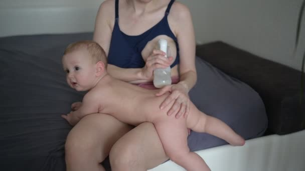 Jovem mãe com recém-nascido bonito bebê menino nu, segurando-o nos braços, usando abraço bomba de mama e amamenta com leite materno. Criança saudável, conceito de hospital e maternidade feliz. Berçário. — Vídeo de Stock
