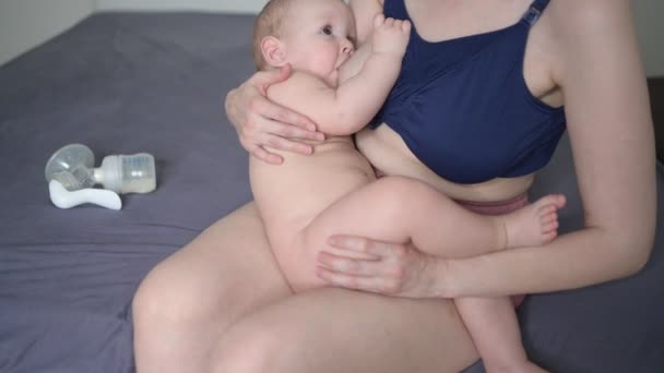 Jonge moeder met pasgeboren schattige baby naakte baby jongen, houdt hem op de armen, met behulp van borstpomp knuffelen en borstvoeding met moedermelk. Gezond kind, concept van ziekenhuis en gelukkig moederschap. Kwekerij. — Stockvideo