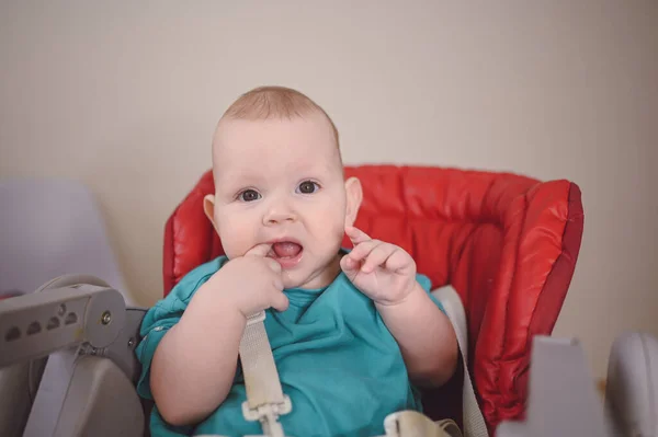 Pequeño niño divertido recién nacido emocional sentado en la silla alta de alimentación. Expresiones faciales del bebé y plantilla de embalaje de mercancías. Niño sano, concepto de hospital y maternidad feliz. Bebé.. —  Fotos de Stock