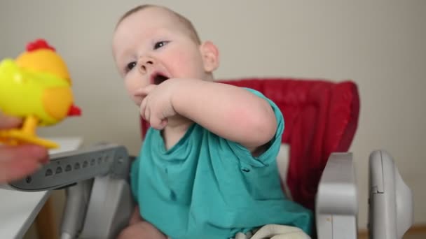 Lite känslomässigt nyfödd rolig liten pojke sitter på mata barnstol. Baby ansiktsuttryck och varor förpackning mall. Friska barn, begreppet sjukhus och lycklig moderskap. Spädbarn. — Stockvideo