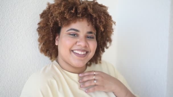 Mooie vrolijke glimlachende ronding plus size Afrikaanse zwarte vrouw afro haar met make-up poseren in beige t-shirt op witte achtergrond. Lichaamsimperfectie, lichaamsacceptatie, lichaamspositief en diversiteitsconcept — Stockvideo