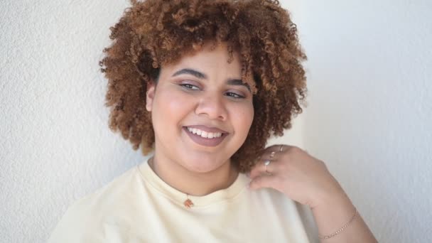 Mooie vrolijke glimlachende ronding plus size Afrikaanse zwarte vrouw afro haar met make-up poseren in beige t-shirt op witte achtergrond. Lichaamsimperfectie, lichaamsacceptatie, lichaamspositief en diversiteitsconcept — Stockvideo