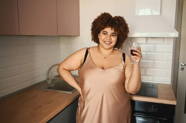 Indah melengkung ditambah ukuran Afrika hitam wanita afro rambut minum anggur merah pada gaya skandinavia modern interior desain. Ketidaksempurnaan tubuh, penerimaan tubuh, tubuh konsep positif dan keragaman — Stok Foto