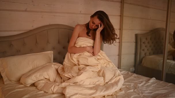 Atrakcyjna pół naga młoda kobieta rozciągająca się w sypialni z beżową pościelą budząca się sama szczęśliwa koncepcja, obudzona po zdrowym śnie w przytulnym wygodnym łóżku i materacu cieszyć się dzień dobry. — Wideo stockowe