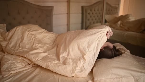 Депрессивная женщина, измученная беспокойным сном, измучена и страдает от бессонницы, плохих снов или кошмаров, психологических проблем. Неудобная кровать или матрас. — стоковое видео