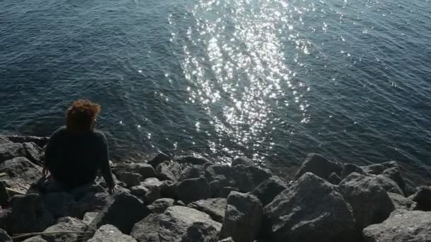 Back view plus size Afrikaanse zwarte vrouw afro haar buiten genieten van rustige avond vakantie aan zee bij zonsondergang, zonnig weer, rotsen, blauwe oceaan water. Begrip "positieve diversiteit" — Stockvideo
