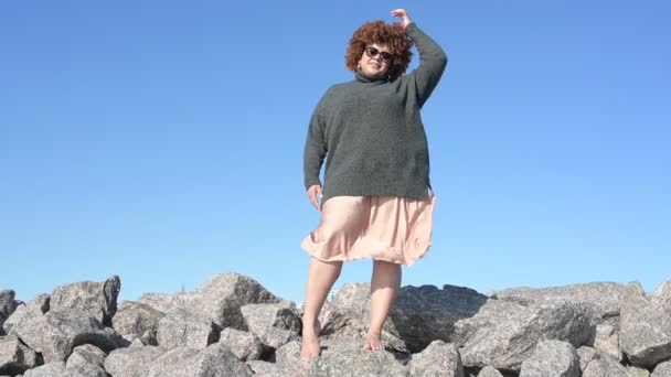 Hermosa sonrisa feliz más el tamaño Africano negro mujer afro pelo en suéter gris al aire libre disfrutando de un clima soleado brillante y el cielo azul. Imperfección corporal, aceptación cuerpo concepto de diversidad positiva — Vídeos de Stock