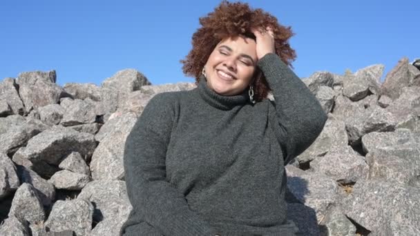 Mooie vrolijke glimlach plus size Afrikaanse zwarte vrouw afro haar in grijze trui outdoor genieten van helder zonnig weer en blauwe hemel. Lichaamsimperfectie, acceptatie lichaam positief diversiteitsconcept — Stockvideo