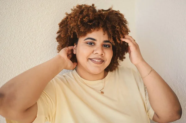 Linda feliz sorrindo curvy plus size Africano preto mulher afro cabelo com maquiagem posando em bege t-shirt no fundo branco. Imperfeição corporal, aceitação corporal, corpo positivo e conceito de diversidade — Fotografia de Stock