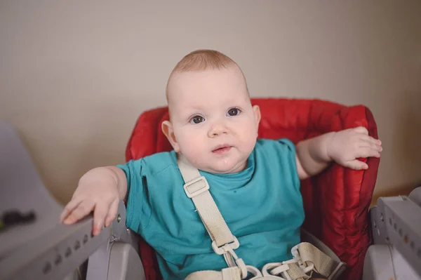 Pequeño niño divertido recién nacido emocional sentado en la silla alta de alimentación. Expresiones faciales del bebé y plantilla de embalaje de mercancías. Niño sano, concepto de hospital y maternidad feliz. Bebé.. —  Fotos de Stock