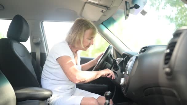 Happy senior woman driving sitting in new car, wearing seat belts, arranca el motor, preparándose para el primer viaje disfrutando del viaje.Cursos de conducción y concepto de seguro de vida. Concepto de actividad para jubilados. — Vídeo de stock