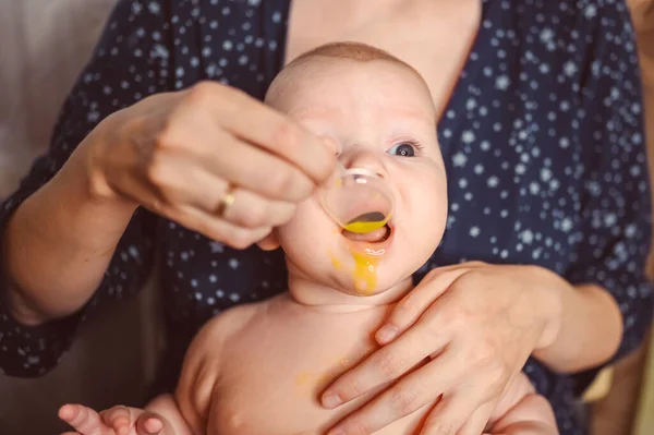 Madre y recién nacido divertido llanto emocional bebé desnudo bebé toma medicación líquida o jarabe de medicina antipirética de cuchara. Niño sano, concepto de hospital y maternidad feliz. Vivero. —  Fotos de Stock