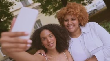 Güzel, mutlu, lezbiyen, Afro-Amerikan çift yazın şehrin sokaklarında selfie çekiyorlar. LGBT toplum konsepti. Bayan arkadaşlar gülümsüyor, birlikte aşk anlarının tadını çıkarıyorlar.