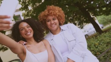 Güzel, mutlu, lezbiyen, Afro-Amerikan çift yazın şehrin sokaklarında selfie çekiyorlar. LGBT toplum konsepti. Bayan arkadaşlar gülümsüyor, birlikte aşk anlarının tadını çıkarıyorlar.