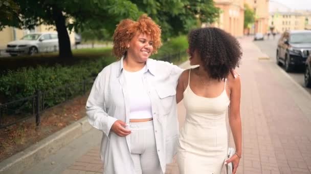 Jolie belle lesbienne heureuse couple afro-américain marche étreignant autour du paysage de la rue de la ville en été. Concept de communauté LGBT. Des amies souriantes profitant de moments d'amour ensemble — Video