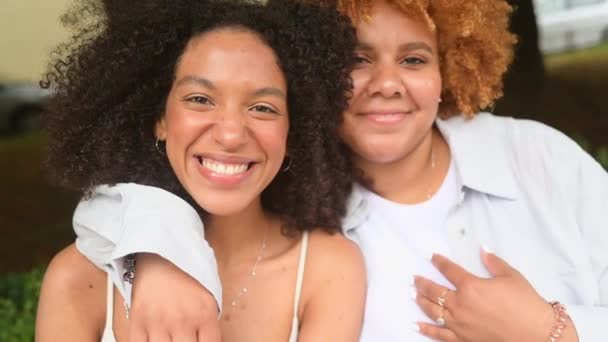 Güzel, güzel, mutlu, Afro-Amerikan bir çift yazın şehrin sokaklarında sarılıyor. LGBT toplum konsepti. Bayan arkadaşlar gülümsüyor, birlikte aşk anlarının tadını çıkarıyorlar. — Stok video