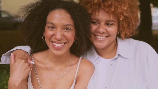 Nahaufnahme Porträt schöne schöne glückliche lesbische afroamerikanische Paar umarmen sich in der Stadt Straßenlandschaft im Sommer. LGBT Community Konzept. Freundinnen lächeln und genießen gemeinsam Liebesmomente — Stockvideo