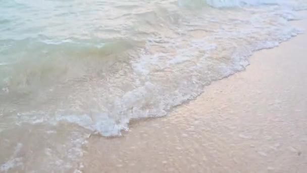 Крупним планом текстура поверхні морської або океанічної хвилі, яка приходить на піщане узбережжя. Натуральний фон з бризками води та піни. Повільний рух літня концепція відпустки . — стокове відео