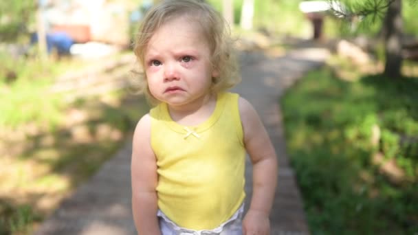 Close up portrait of little funny cute blonde girl child toddler in yellow bodysuit crying outside at summer. Childish tantrum. Healthy childhood concept. — Stock Video