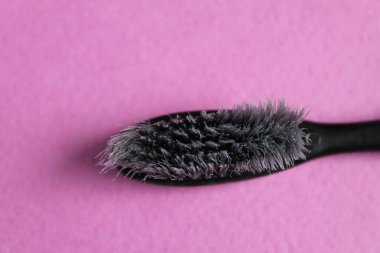 Fuşya üzerinde siyah gri eski kullanılmış diş fırçası. Fotokopi alanının kızlar için parlak arkaplan rengi.