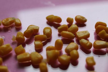 Pembe arkaplandaki mısır taneleri. Üst görünüm yiyecek arka planı sebze.