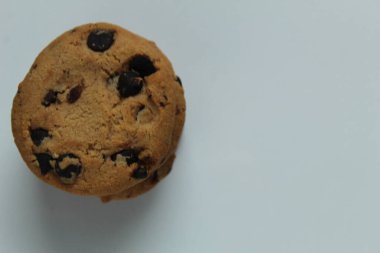 Çikolata damlalı kurabiyeler fotokopi alanının beyaz açık gri arka planında üst görünümde istiflenmiştir