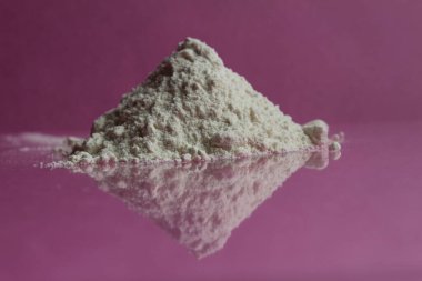 En yüksek ya da birinci sınıf beyaz un pembe bir fuşya ayna arka planında bir yığın yatar. Yansıma kenarı görünümü olan bir kopya alanı vardır.