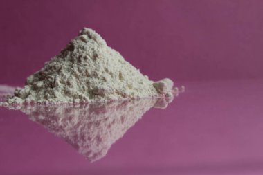 En yüksek ya da birinci sınıf beyaz un pembe bir fuşya ayna arka planında bir yığın yatar. Yansıma kenarı görünümü olan bir kopya alanı vardır.