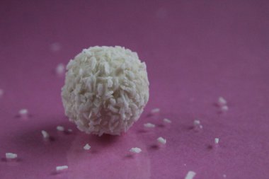 Yeşil çimenlerin üzerine serpiştirilmiş hindistan cevizi serpiştirilmiş beyaz bir şeker.