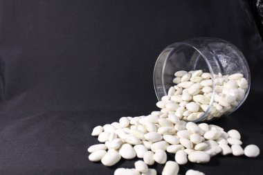 uzayın bir kopyasının siyah arka planına cam bir kavanozdan fasulye döküldü..