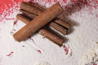 Üç çubuk tarçın beyaz bir arka planda uzayın bir kopyasını pişiriyor..