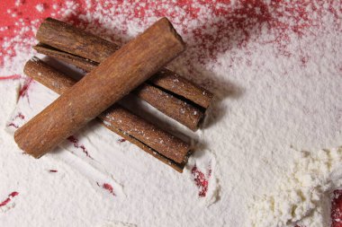 Üç çubuk tarçın beyaz bir arka planda uzayın bir kopyasını pişiriyor..