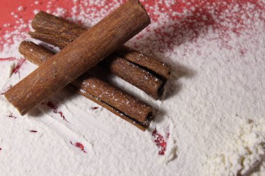 Üç çubuk tarçın beyaz bir arka planda uzayın bir kopyasını pişiriyor..