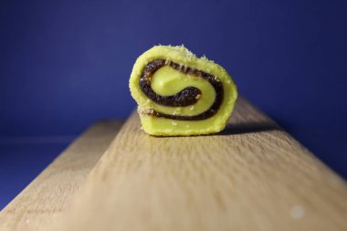 Ahşap bir kaide üzerinde, mavi bir arkaplanda, uzayın bir kopyasıyla birlikte pastila marmeladı..