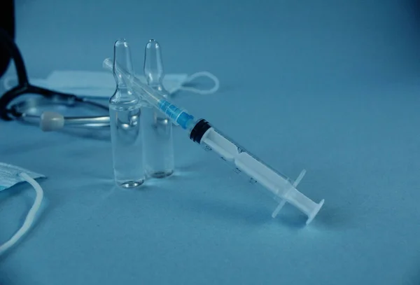 接种疫苗注射器和两瓶带有蓝色底色带有复制空间的麻风病疫苗 — 图库照片