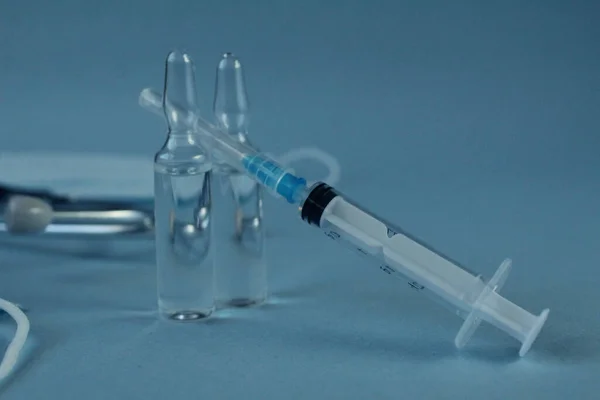 接种疫苗注射器和两瓶带有蓝色底色带有复制空间的麻风病疫苗 — 图库照片