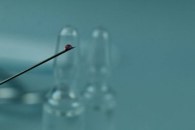 Aşı, mavi arkaplandaki bir iğneye kan ilacı düşürür..