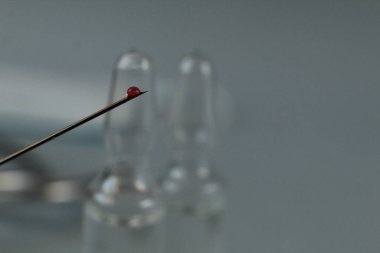 Aşı, mavi arkaplandaki bir iğneye kan ilacı düşürür..