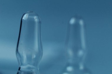 Kopya aşılama arkaplanlı mavi ışık arka planında şişe camı yakın plan.