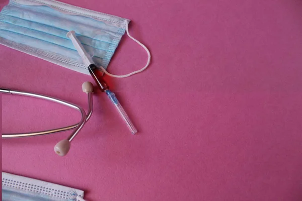 Tıbbi arka plan maskesi steteskop şırıngası pembe arka planda metin kopyalama alanı için bir yer.
